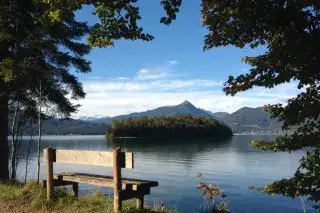 Eine Bank steht am Ufer des Walchensees