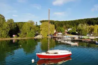 Segelboot legt vom Steg auf dem Wörthsee ab