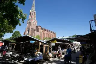 Blick auf die Mariahilfkirche während der Auer Dult - Jakobidult mit Sonne und strahlend blauem Himmel. 