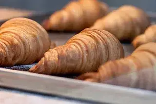 Frisch gebackene Croissants auf einem Backblech. Frisch gebackene Croissants auf einem Backblech.