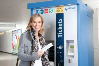 Frau mit Streifenkarte vor Fahrkartenautomat der MVG Frau mit Streifenkarte vor Fahrkartenautomat der MVG