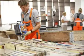 210218-awm-halle2-schallplatten Mitarbeiter der Halle 2 sortiert Schallplatten