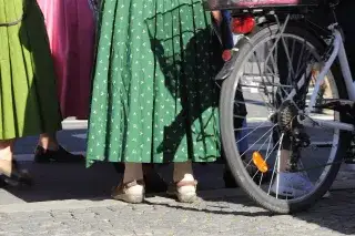 Frauen im Dirndl mit Fahrrad unterwegs zum Oktoberfest.