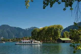 Ein kleiner Dampfer fährt auf dem Tegernsee Ein kleiner Dampfer fährt auf dem Tegernsee