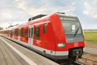 Eine rote S-Bahn steht an einme Bahnsteig zur Abfahrt bereit