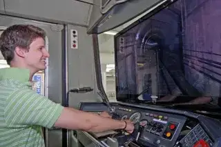 Ein junger Mann im U-Bahnsimulator im MVG Museum