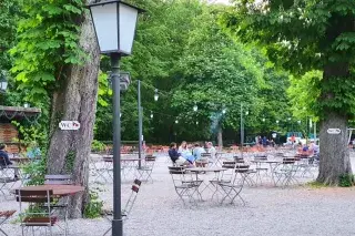 20210816_Biergarten Hirschau Unter großen Kastanien stehen Tische und Stühle des Biergartens Hirschau im Englischen Garten.