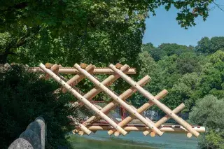 Beim Kunstprojekt "Bridge Sprout" ragt ein hölzerner Brückenkopf über die Isar