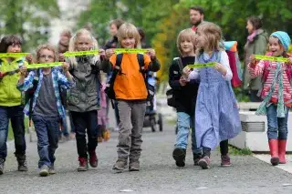 Schulkinder mit Reflektoren auf dem Weg zur Schule