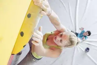 Eine Frau klettert an der Kletterwand Eine Frau klettert an der Kletterwand