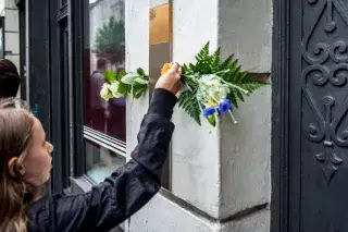 Mädchen bringt weiße Rose an Plakette an