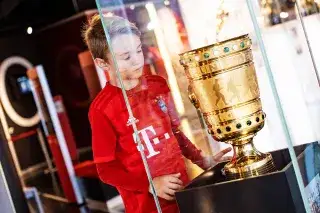 Ein Bub bewundert den ausgestellten DFB-Pokal