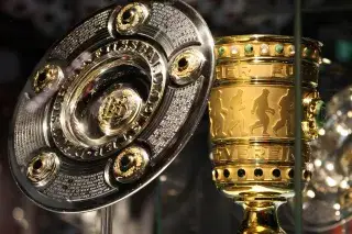 Meisterschale und DFB-Pokal in einer Vitrine