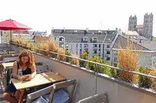 Eine Frau sitzt auf der sonnigen Dachterrasse des Flushing Meadows Eine Frau sitzt auf der sonnigen Dachterrasse des Flushing Meadows