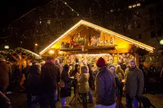 Besucher des Haidhauser Weihnachtsmarkts vor einem Standl