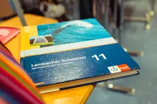 Mathebuch auf einem Stuhl Mathebuch auf einem Stuhl