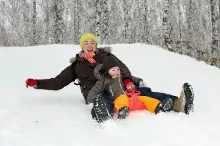 Mutter und Kind haben Spaß beim Rodeln