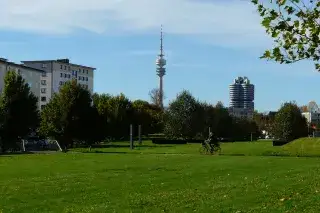 Ein Mann radelt durch den Petuelpark in Schwabing