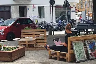 Eine Frau sitzt auf einer Stadtterasse Eine Frau sitzt auf einer Stadtterasse
