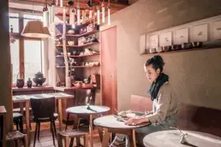 Eine junge Frau genießt eine Tasse Tee im Tushita Teehaus Eine junge Frau genießt eine Tasse Tee im Tushita Teehaus