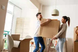 Ein Mann und eine Frau tragen einen Umzugskarton Ein Mann und eine Frau tragen einen Umzugskarton