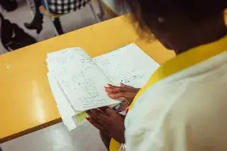 Eine Schülerin der Städtischen Franz-Auweck-Abendschule blättert in ihren Unterlagen Eine Schülerin der Städtischen Franz-Auweck-Abendschule blättert in ihren Unterlagen