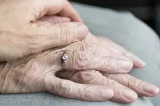 Pflege Hände Eine Person hält die Hände einer älteren Person