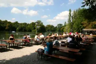 Menschen sitzen im Biergarten am Seehaus im Englischen Garten