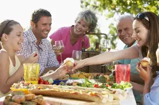 Eine Gruppe von Menschen sitzt an einem Picknicktisch auf dem Essen steht