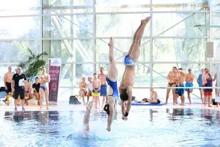 Turmspringer tauchen kopfüber ins Wasser ein