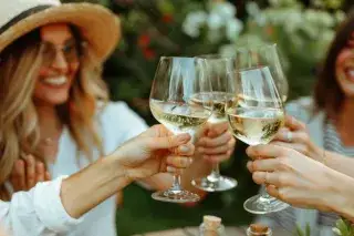 Sommer-Hofffest: Menschen stoßen mit Weingläsern an