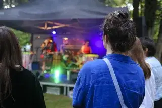 Sommerfest der Monacensia: Zuschauende blicken auf die Musikbühne