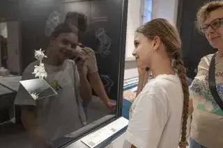 Mädchen hört in Ohrhörer im Biotopia Lab Mädchen hört in Ohrhörer im Biotopia Lab