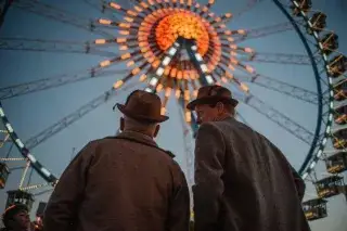 Zwei Besucher auf dem Oktoberfest vor dem Riesenrad