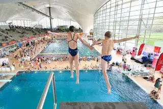 Zwei Kinder springen vom Turm in der Olympia-Schwimmhalle Zwei Kinder springen vom Turm in der Olympia-Schwimmhalle