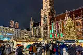 Münchner Christkindlmarkt am Marienplatz mit erleuchtetem Christbaum bei Dunkelheit