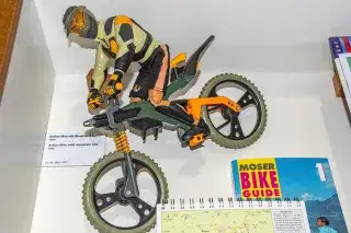 Spielzeug-Mountainbike mit Action Man-Puppe. 
