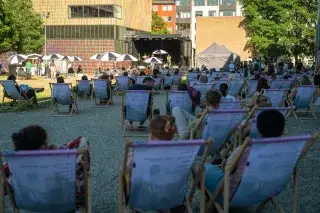Menschen in Liegestühlen bei sonnigem Wetter auf dem Kunstareal-Fest