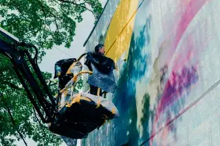 Daniel Man arbeitt am neuen Mural am KUNSTLABOR 2