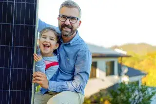 Vater und Tochter vor einer PV-Anlage