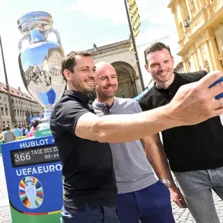 Drei Männer machen ein Selfie mit der großen Kopie des EM-Pokals am Odeonsplatz in München