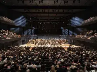 Die Münchner Philharmoniker auf der Bühne vor Publikum in der Isarphilharmonie