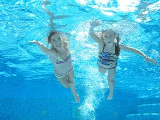Schwimmende Kinder unter Wasser