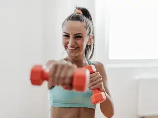 Frau beim Zirkeltraining mit Kurzhantel