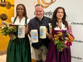 Wiesn-Chef Dr. Christian Scharpf und die Designerinnen des Oktoberfest-Motivs 2025 bei der Vorstellung des Festkrugs 2025