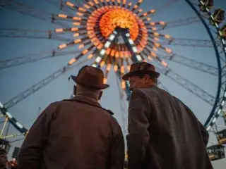 Zwei Besucher auf dem Oktoberfest vor dem Riesenrad