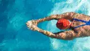 Eine Schwimmerin im Hallenbad zieht ihre Bahnen