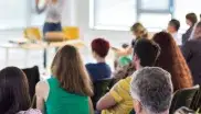 Erwachsene lauschen einem Weiterbildungsseminar