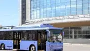 Der DB Oberbayernbus steht vor einem Firmengebäude.