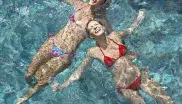 Freundinnen schwimmen im Hallenbad